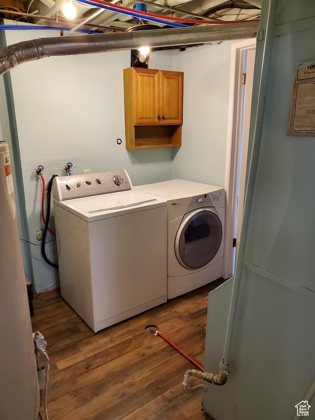 laundry room with independent washer and dryer, cabinet space, and wood finished floors