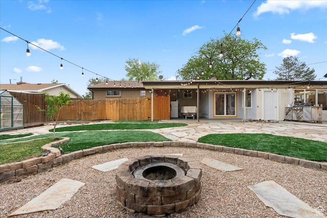 back of house featuring an outdoor fire pit and a patio