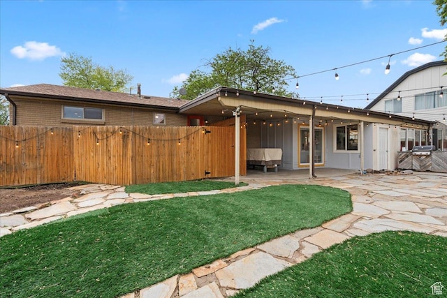 back of house with a patio, brick siding, and a gate