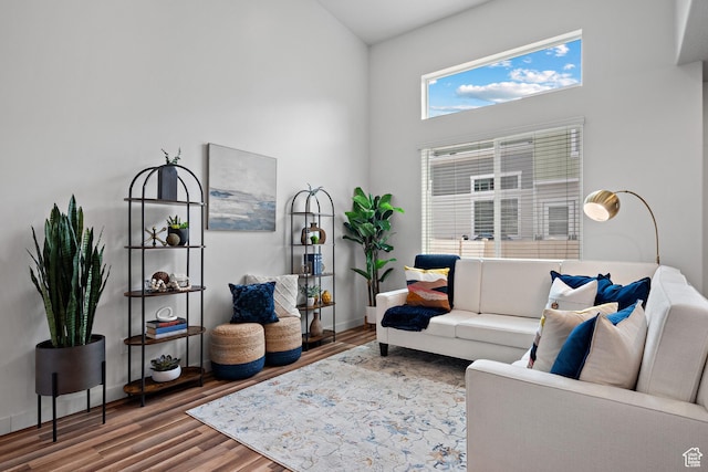 living area featuring wood finished floors and a towering ceiling