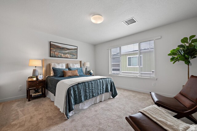 carpeted bedroom with baseboards and a textured ceiling