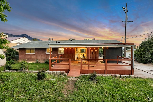 476 E 3050 N, North Ogden, UT 84414 - view of front of house featuring brick siding, a wooden deck, a front yard, and roof with shingles