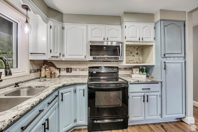 476 E 3050 N, North Ogden, UT 84414 - kitchen featuring stainless steel microwave, black range with electric stovetop, a sink, and decorative backsplash