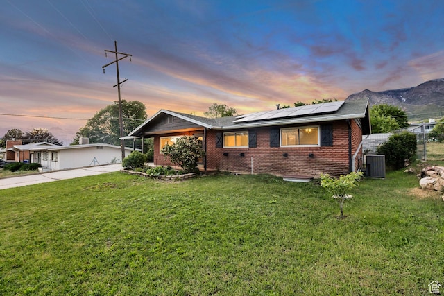 476 E 3050 N, North Ogden, UT 84414 - view of front of property featuring solar panels, brick siding, concrete driveway, and central air condition unit