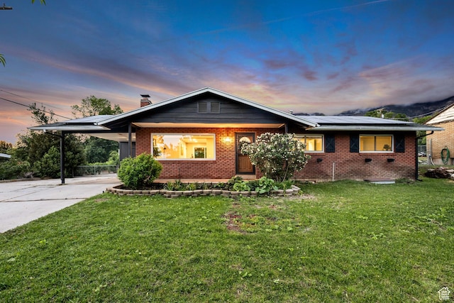 476 E 3050 N, North Ogden, UT 84414 - view of front facade featuring brick siding, solar panels, concrete driveway, a front yard, and an attached carport