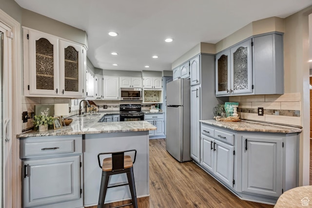 476 E 3050 N, North Ogden, UT 84414 - kitchen with freestanding refrigerator, black electric range oven, stainless steel microwave, a peninsula, and a sink