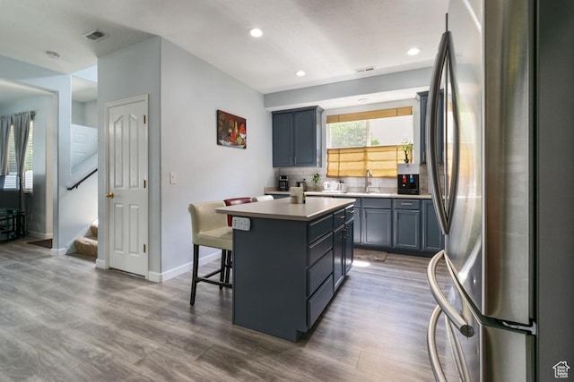kitchen with freestanding refrigerator, a center island, dark wood-style floors, tasteful backsplash, and recessed lighting