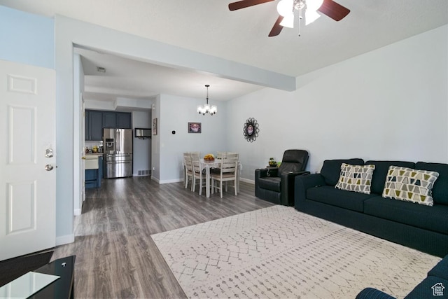 living room featuring wood finished floors, a ceiling fan, baseboards, and a chandelier
