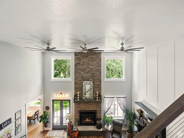538 W 600 S, Logan, UT 84321 - living room featuring a stone fireplace, plenty of natural light, wood finished floors, a high ceiling, and a ceiling fan