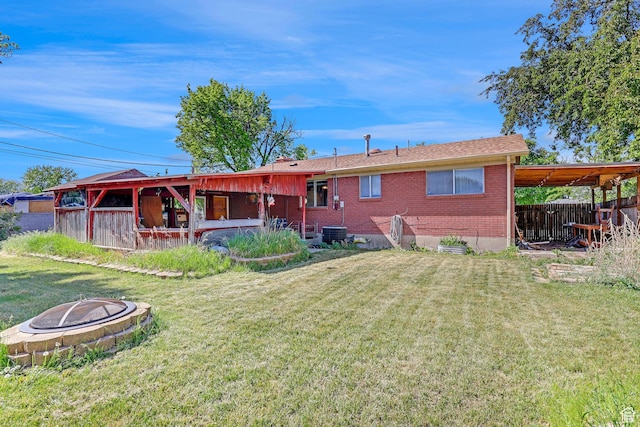 3927 W Rawhide Dr S, West Valley City, UT 84120 - rear view of property with an outdoor fire pit, brick siding, and central AC unit