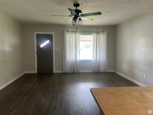 foyer entrance with dark wood finished floors, ceiling fan, baseboards, and a textured ceiling
