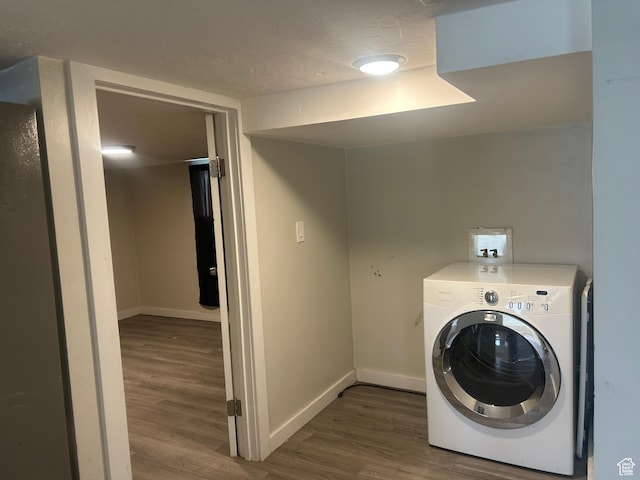 clothes washing area with washer / dryer, dark wood-style flooring, and baseboards