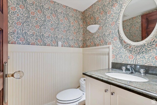 34 S Haxton Pl, Salt Lake City, UT 84102 - half bathroom featuring wallpapered walls, toilet, vanity, and wainscoting