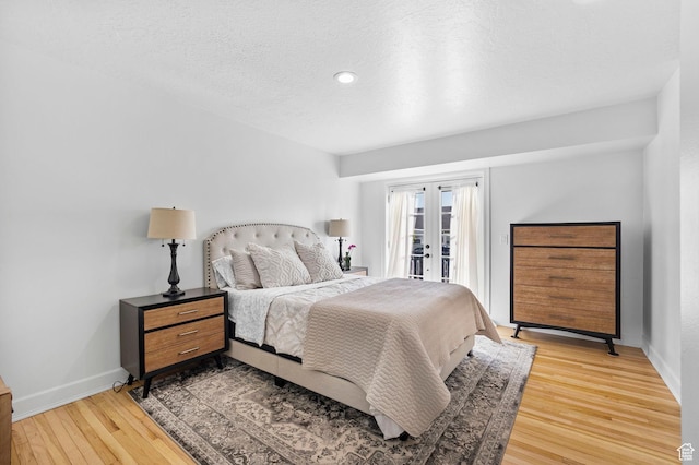 13956 S Wild Colt Cir, Herriman, UT 84096 - bedroom featuring access to exterior, light wood finished floors, baseboards, a textured ceiling, and recessed lighting