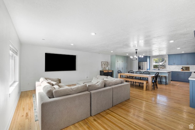 13956 S Wild Colt Cir, Herriman, UT 84096 - living room featuring a chandelier, light wood finished floors, recessed lighting, a textured ceiling, and baseboards