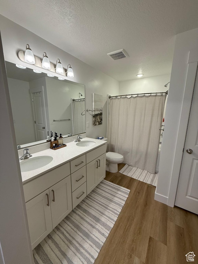 81 W 925 N, Brigham City, UT 84302 - full bathroom with wood finished floors, toilet, a shower with shower curtain, a textured ceiling, and double vanity