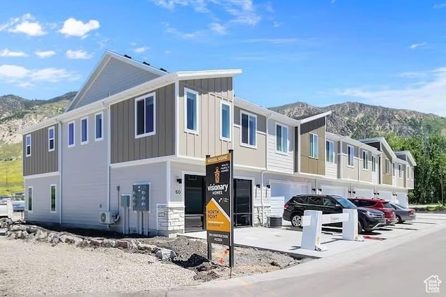 81 W 925 N, Brigham City, UT 84302 - view of front of home featuring a mountain view, board and batten siding, a garage, and a cooling unit