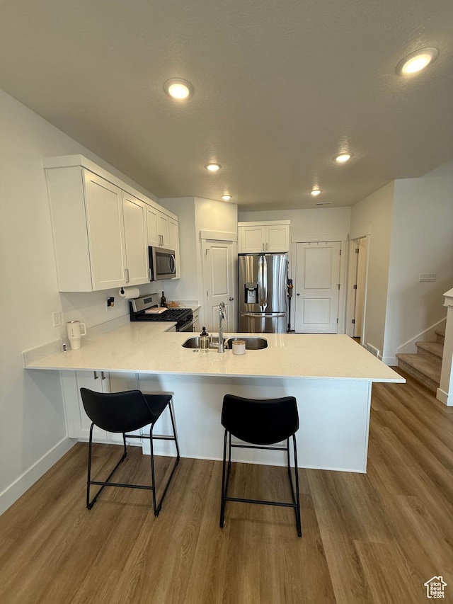 81 W 925 N, Brigham City, UT 84302 - kitchen featuring stainless steel appliances, a sink, a peninsula, a kitchen bar, and baseboards