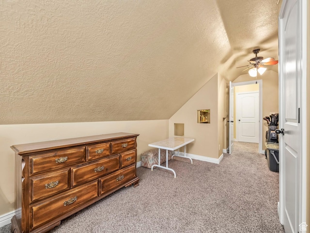 bonus room featuring a textured ceiling, vaulted ceiling, a ceiling fan, carpet, and baseboards