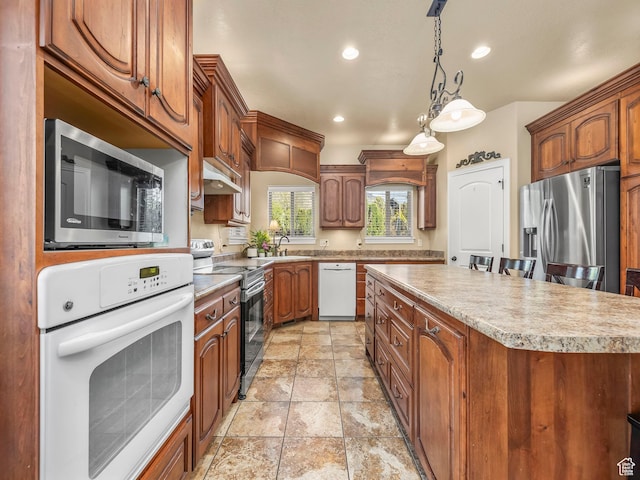 kitchen featuring appliances with stainless steel finishes, a center island, light countertops, recessed lighting, and hanging light fixtures