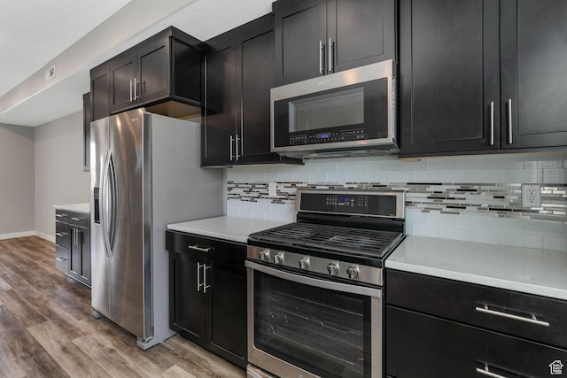 5368 W Sonova Ln S, Herriman, UT 84096 - kitchen with appliances with stainless steel finishes, light wood-type flooring, decorative backsplash, and light countertops