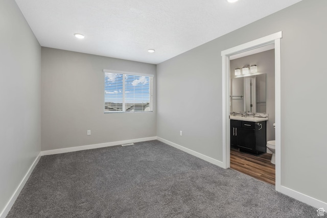 5368 W Sonova Ln S, Herriman, UT 84096 - unfurnished bedroom with dark carpet, baseboards, connected bathroom, and recessed lighting