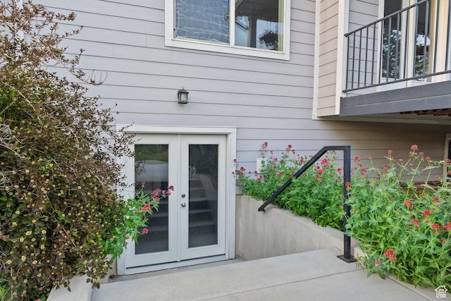 view of exterior entry featuring french doors and a balcony