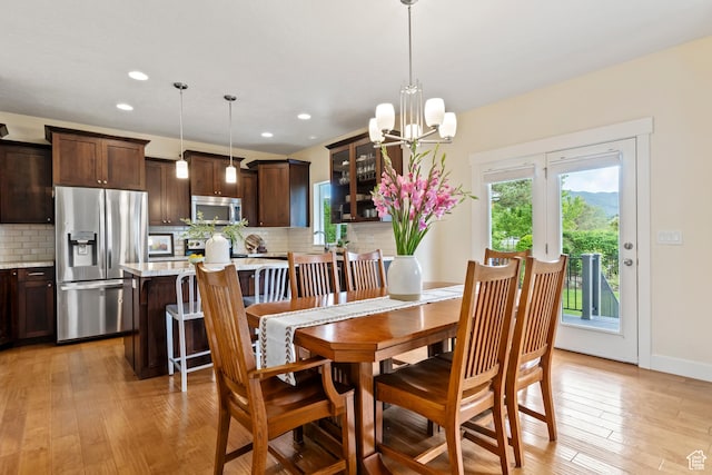dining room with light wood-style flooring, recessed lighting, a chandelier, and baseboards