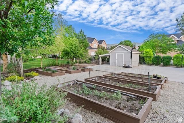 view of yard featuring a garden, an outdoor structure, and fence