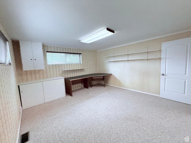 unfurnished office with wallpapered walls, carpet flooring, and crown molding
