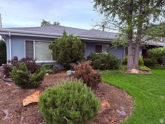 view of front of property with a front yard and roof with shingles