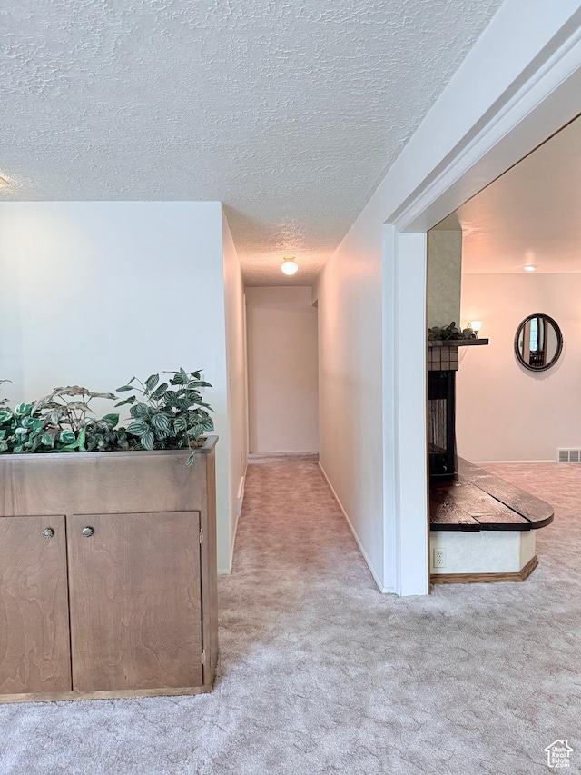 hallway with carpet floors and a textured ceiling