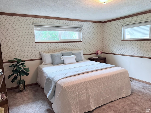 carpeted bedroom with a textured ceiling, ornamental molding, and baseboards