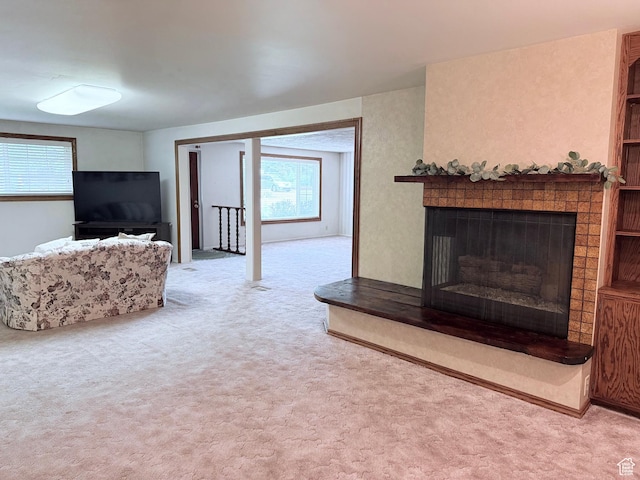living area featuring carpet flooring and a fireplace with raised hearth