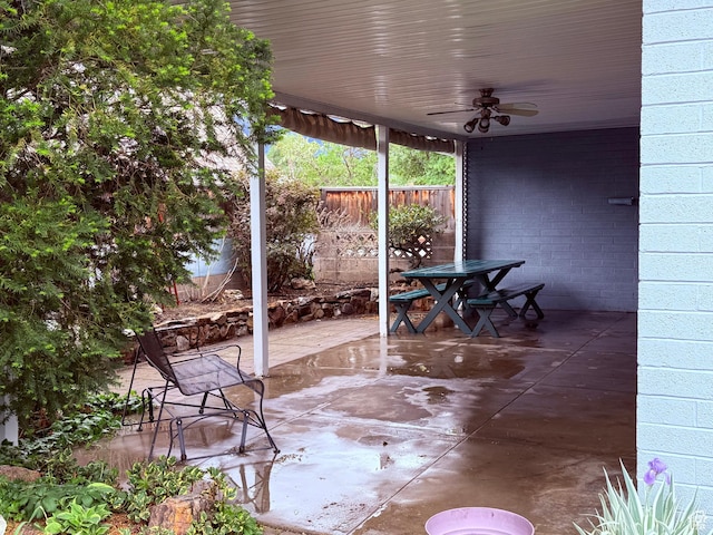 view of patio with ceiling fan, fence, and outdoor dining space