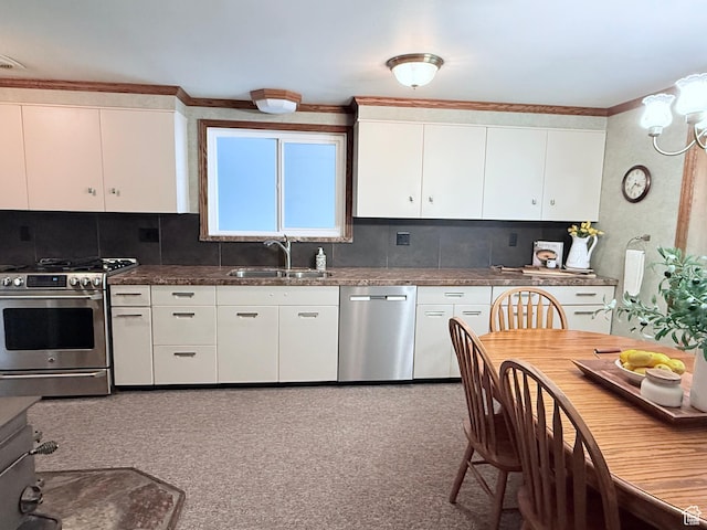 kitchen featuring appliances with stainless steel finishes, a sink, white cabinets, tasteful backsplash, and crown molding