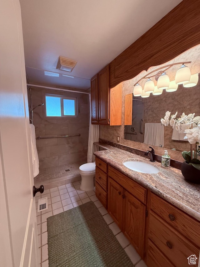 bathroom with tile patterned flooring, a stall shower, vanity, and toilet