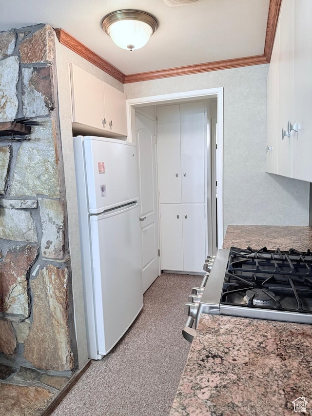 kitchen featuring freestanding refrigerator, white cabinets, light carpet, ornamental molding, and light countertops