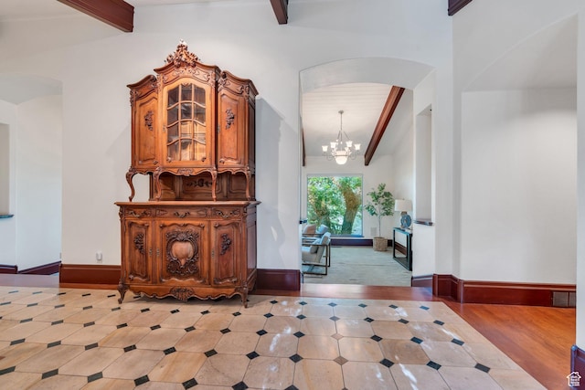 3223 Apache Ln, Provo, UT 84604 - foyer featuring arched walkways, beam ceiling, a chandelier, and baseboards