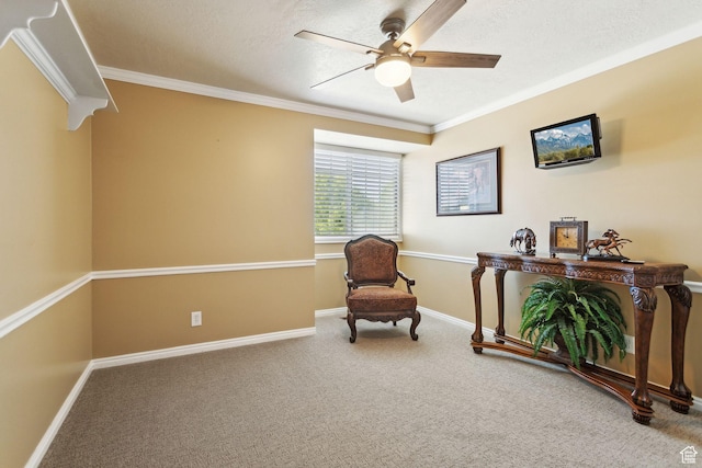 living area featuring ceiling fan, ornamental molding, carpet flooring, baseboards, and a textured ceiling