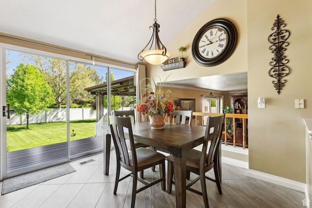 dining space with baseboards and lofted ceiling
