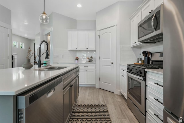 15378 S Skyraider Ln, Bluffdale, UT 84065 - kitchen featuring stainless steel appliances, a sink, light countertops, light wood-type flooring, and white cabinetry