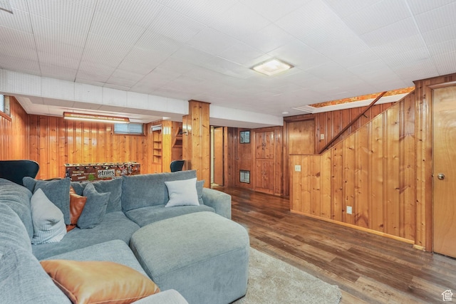 living room featuring wooden walls, wood finished floors, and baseboards