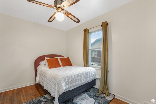 bedroom with wood finished floors, baseboards, and a ceiling fan