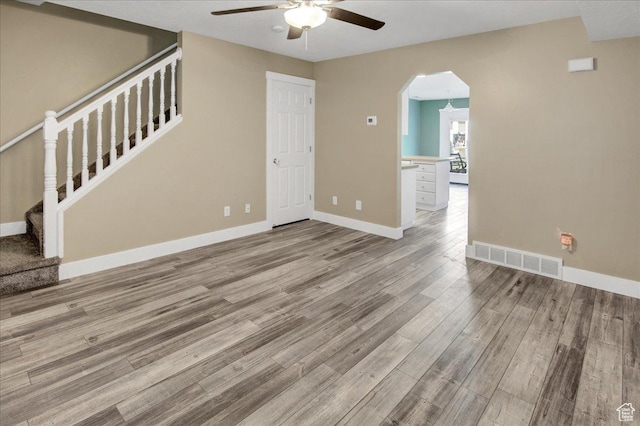 2421 N 400 E Unit M-1, North Ogden, UT 84414 - unfurnished living room with a ceiling fan, wood finished floors, stairway, arched walkways, and baseboards