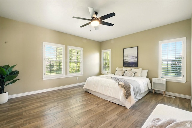 2897 W 3400 N, Benson, UT 84335 - bedroom featuring baseboards, wood finished floors, a ceiling fan, and radiator heating unit