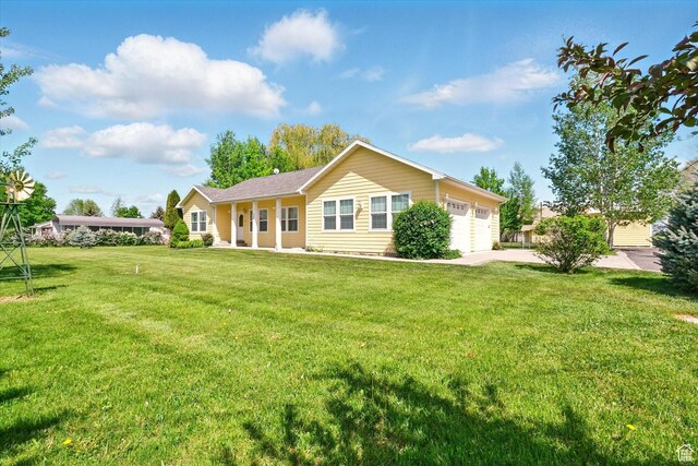 2897 W 3400 N, Benson, UT 84335 - back of property featuring a garage, a yard, and driveway
