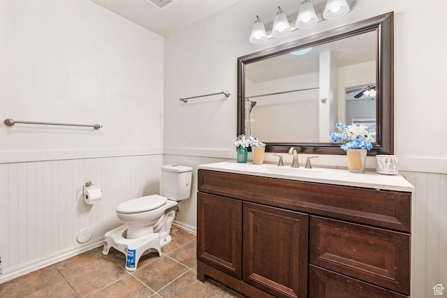 1456 S 430 W, Orem, UT 84058 - bathroom with wainscoting, toilet, vanity, tile patterned floors, and a ceiling fan