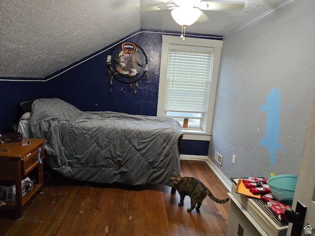 bedroom with wood-type flooring, a textured ceiling, vaulted ceiling, baseboards, and multiple windows