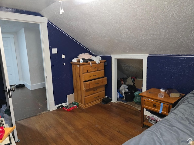 bedroom with a textured ceiling, wood-type flooring, lofted ceiling, and baseboards